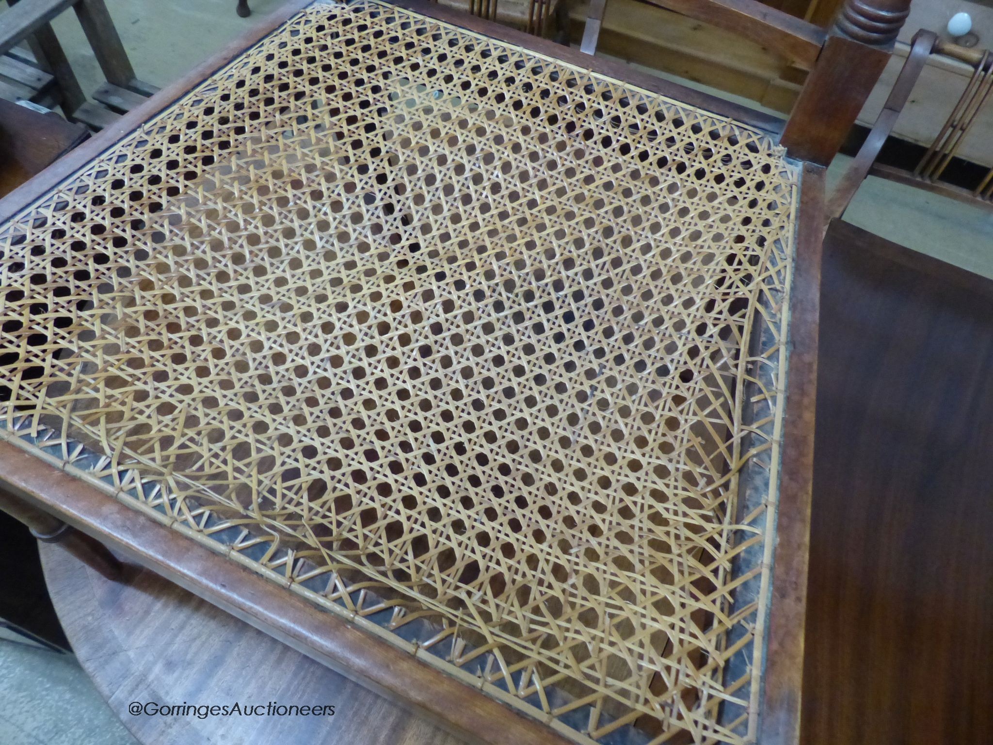 A reproduction mahogany twin pillar extending dining table and a set of six Regency fruitwood caned seated elbow chairs